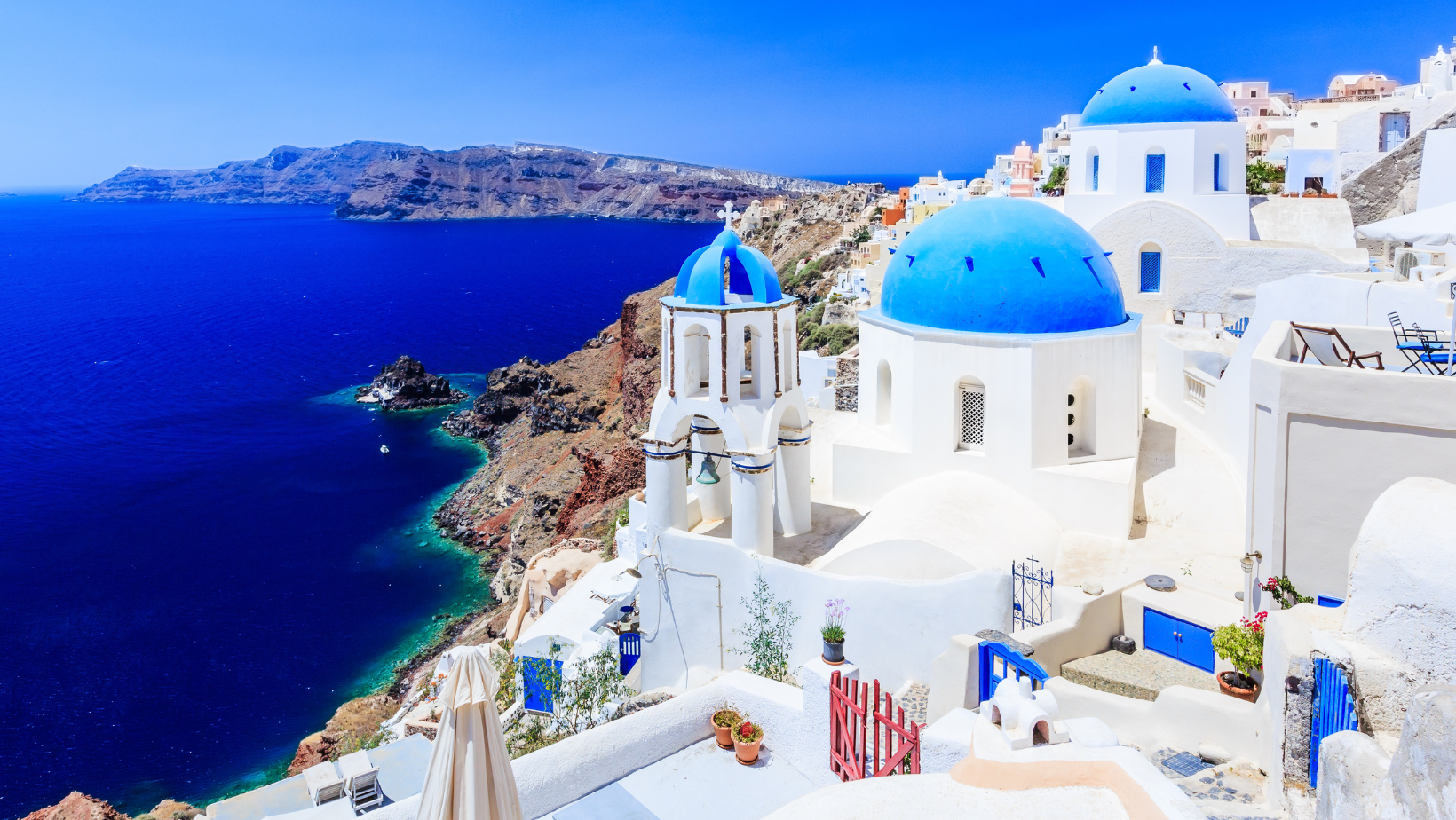 נוף ציורי של יוון - עם כיפות כחולות וחופים