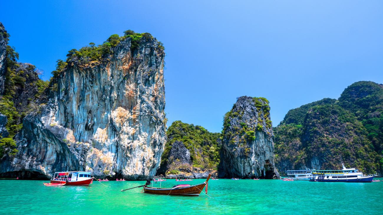 ים כחול עם סירות והרים - נוף תאילנדי
