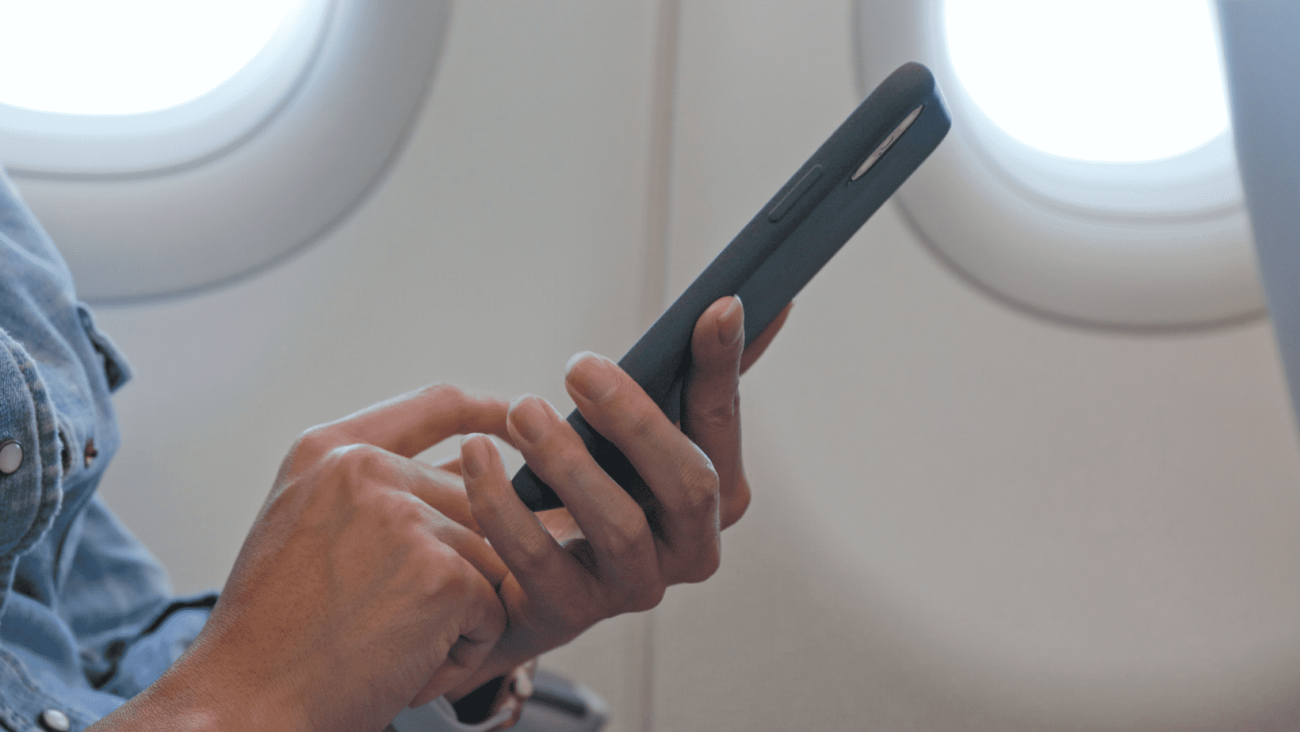 איש במטוס גולש בטלפון אחרי שהשווה מחירי חבילות גלישה