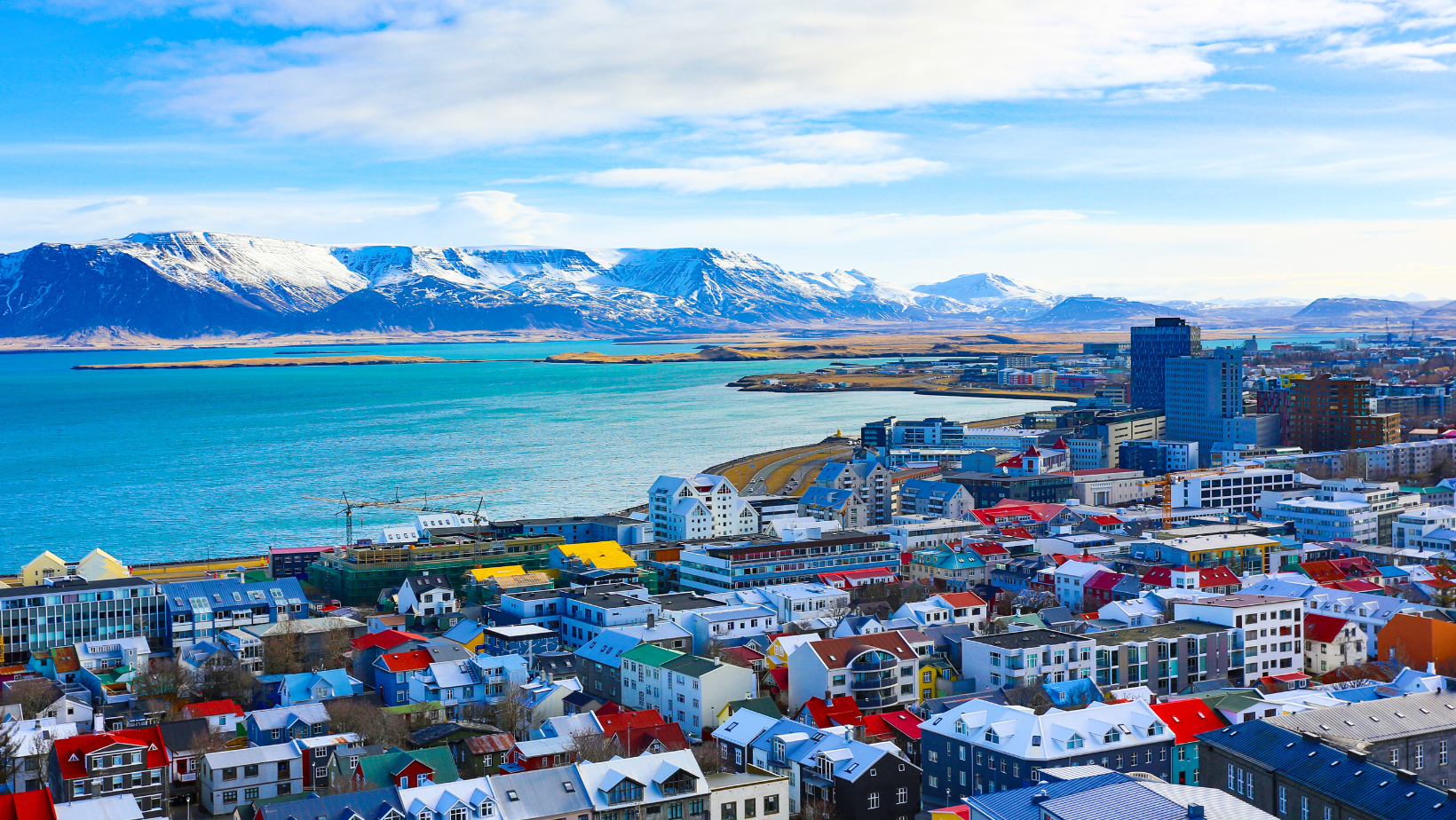 נוף של עיירה באיסלנד עם בתים צבעוניים וברקע הים